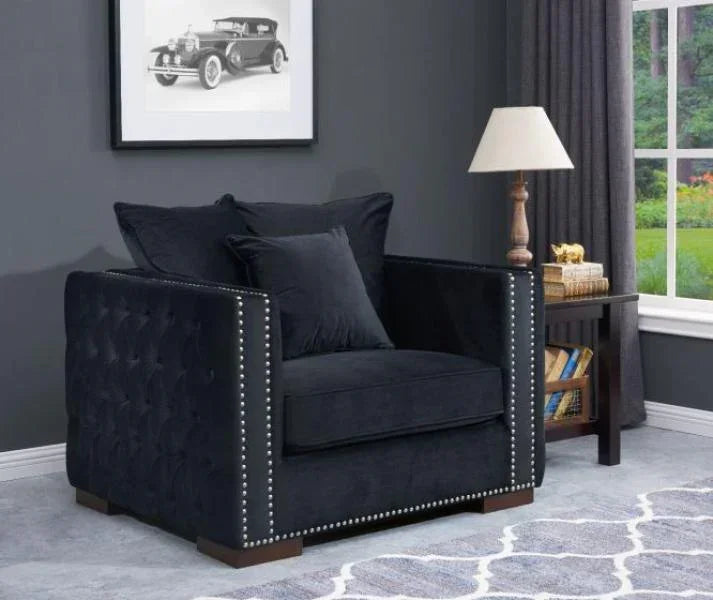 Dark velvet armchair with studded arms beside side table and lamp in living room