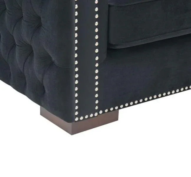 Black fabric sofa corner with button tufting and silver stud detail on arm and base
