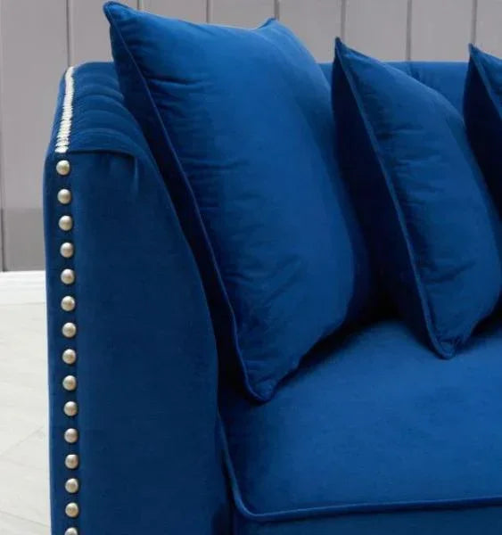 Blue velvet sofa with studded armrest and matching cushions