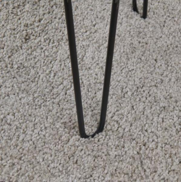 Black metal hairpin furniture leg on beige textured carpet