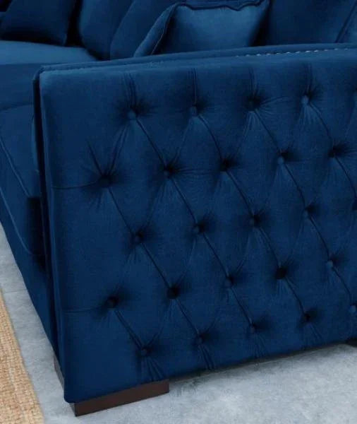 Navy blue velvet sofa with tufted armrest and matching scatter cushions