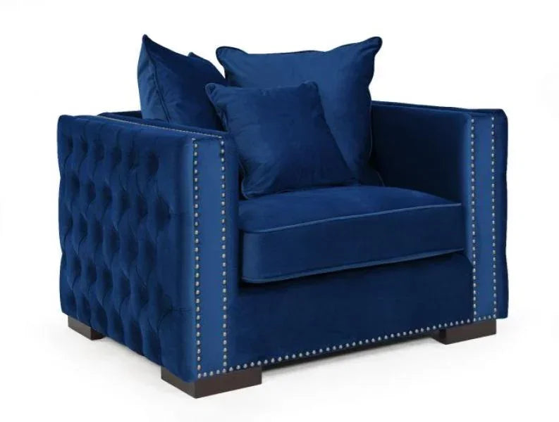 Blue velvet armchair with button-tufted sides, metal stud trim, and square cushions