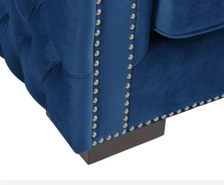 Blue velvet sofa corner with button tufted detail and silver nailhead trim