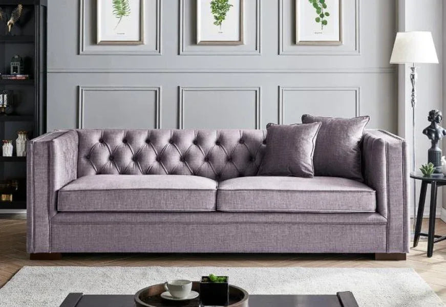 Grey tufted fabric sofa with cushions in a modern living room setting