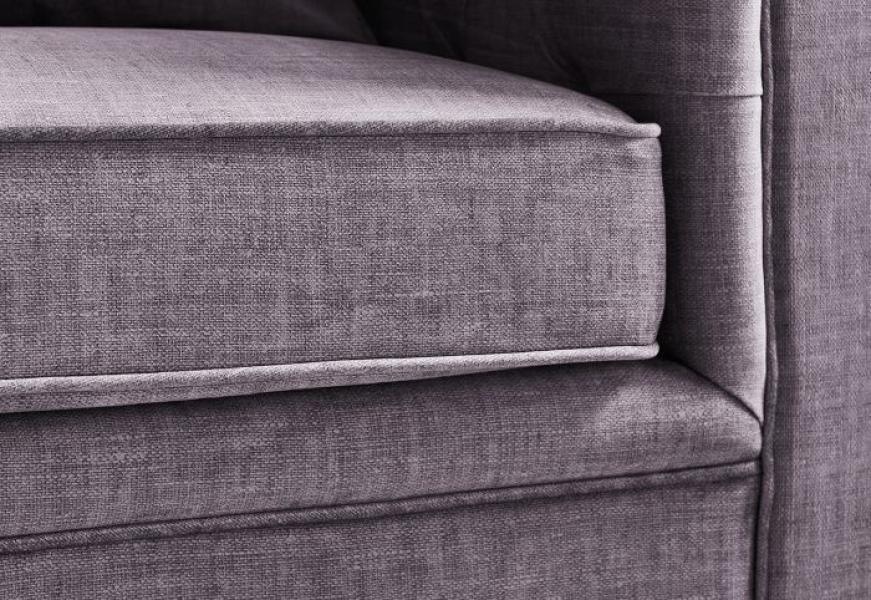 Close-up of grey fabric sofa cushion with piped edge detail