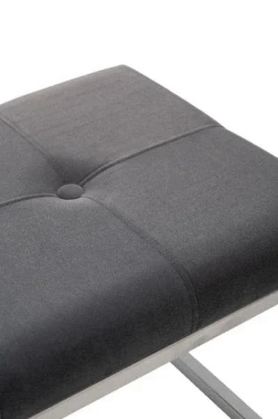 Close-up of grey upholstered dining chair seat with button detail and chrome legs