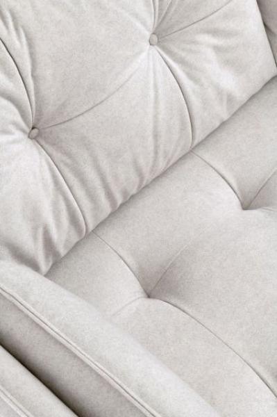 Close up of light grey fabric sofa with tufted backrest and seat cushions