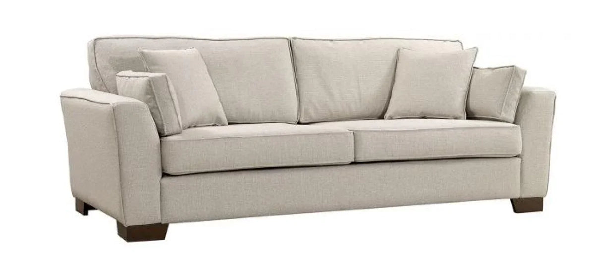 Beige fabric sofa with two seat cushions, three back cushions and four throw pillows on wood legs