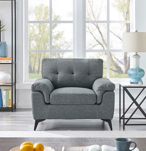 Grey fabric armchair with tufted backrest in bright living room by window
