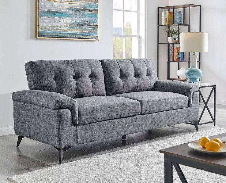 Grey fabric sofa with button tufting, angled legs in modern living room setting