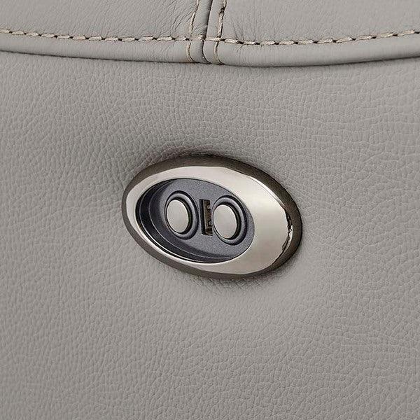 Closeup of electric recliner sofa control panel on light grey leather upholstery