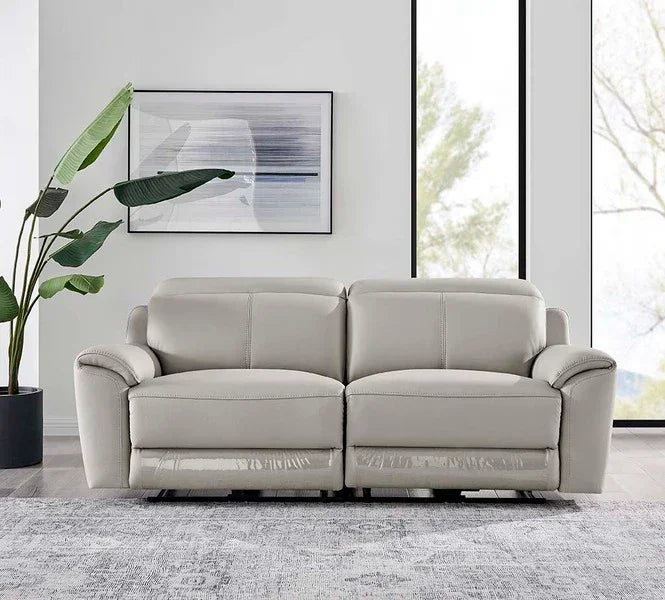 Light grey leather sofa with plush cushions in modern living room setting