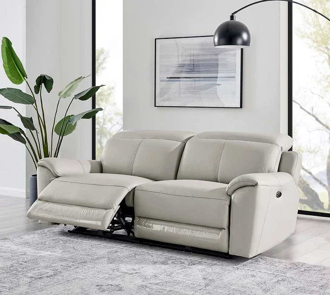 Light grey leather recliner sofa with raised footrest in modern living room setting