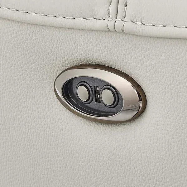Close-up of power recliner switch on cream leather sofa armrest