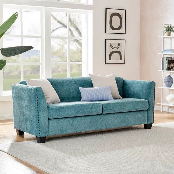 Teal upholstered sofa with slim arms and accent pillows in a bright living room