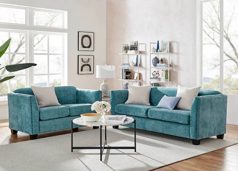 Blue velvet sofa set with scatter cushions in modern living room with large windows