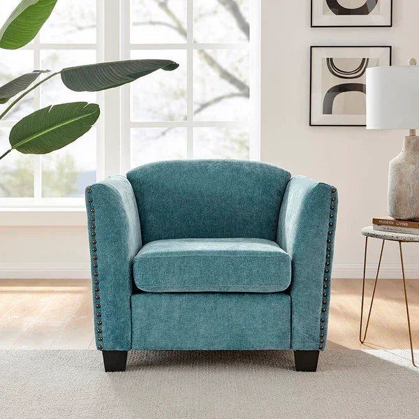 Teal fabric armchair with nailhead trim in bright living room setting