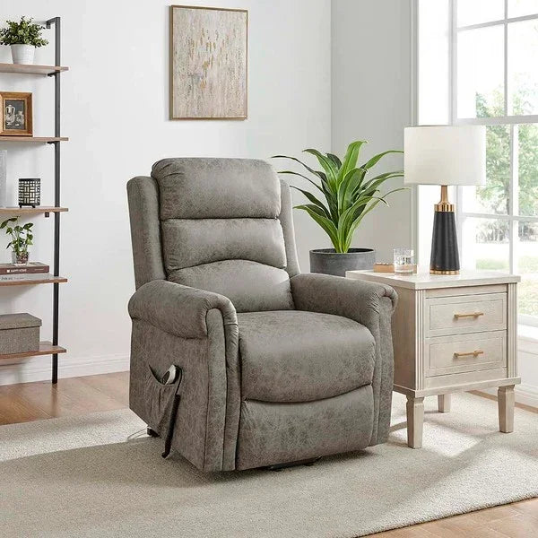 Grey fabric recliner chair in living room next to side table with lamp and houseplant