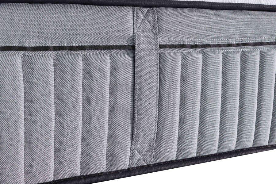 Side view of grey mattress with textured fabric and stitched vertical handles