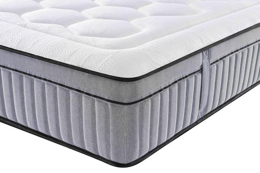 Closeup of grey and white pocket sprung mattress with quilted top and stitched side handles