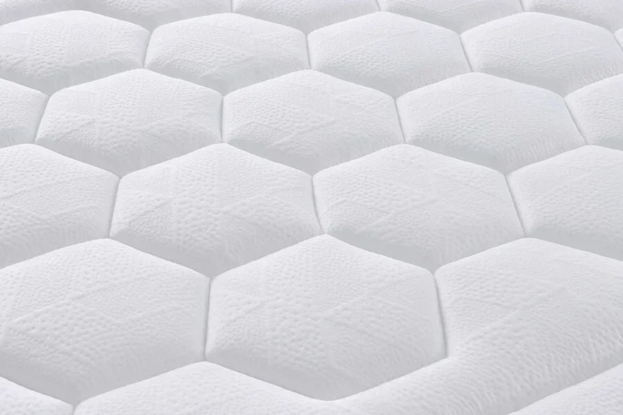 Closeup of white mattress with hexagonal quilted surface texture