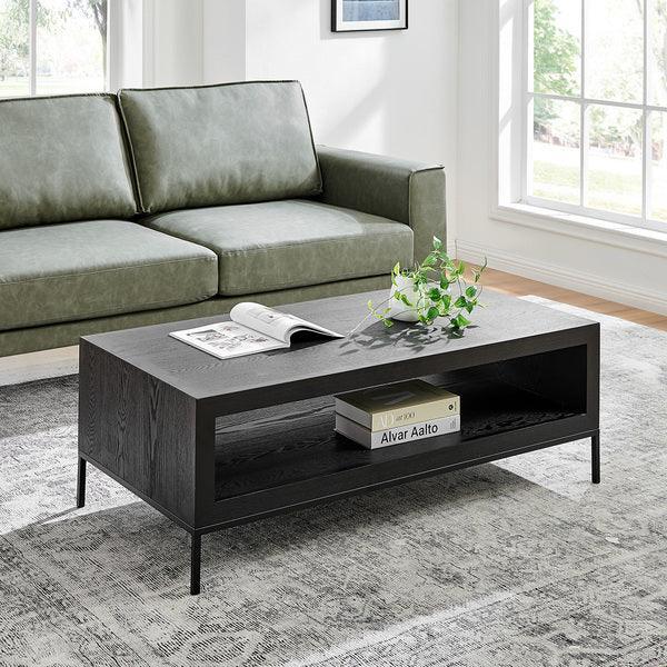 Black wood coffee table with open shelf, book, and plant in modern living room