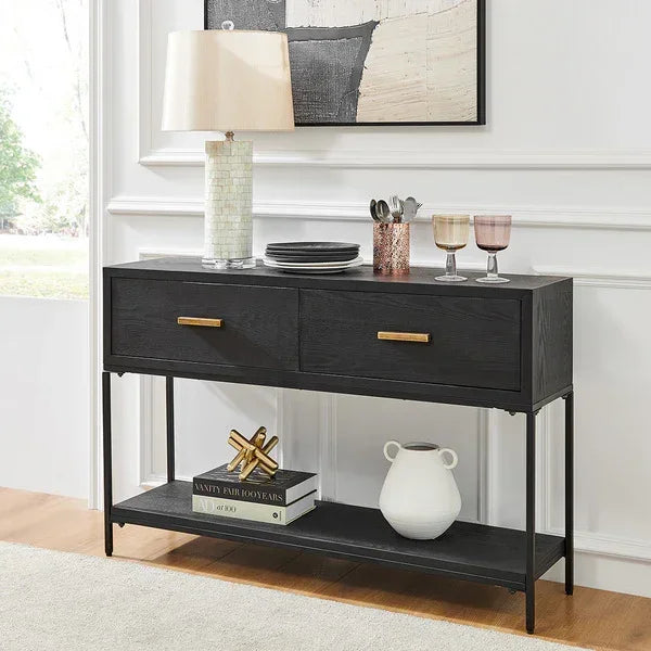 Black console table with gold handles, lower shelf, lamp and glasses in living room