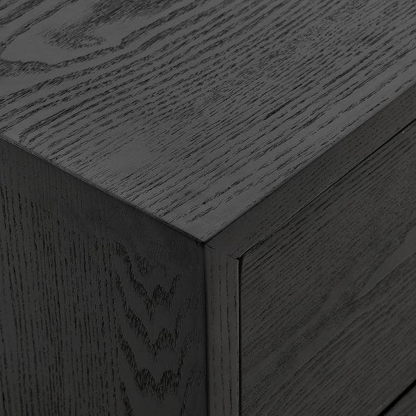 Closeup of black wood cabinet corner with visible grain texture