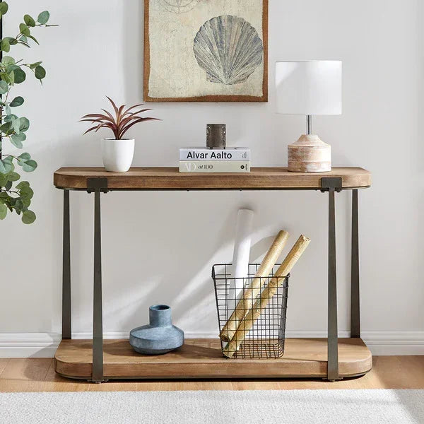 Wood and metal console table with books, lamp, potted plant and storage basket in hallway
