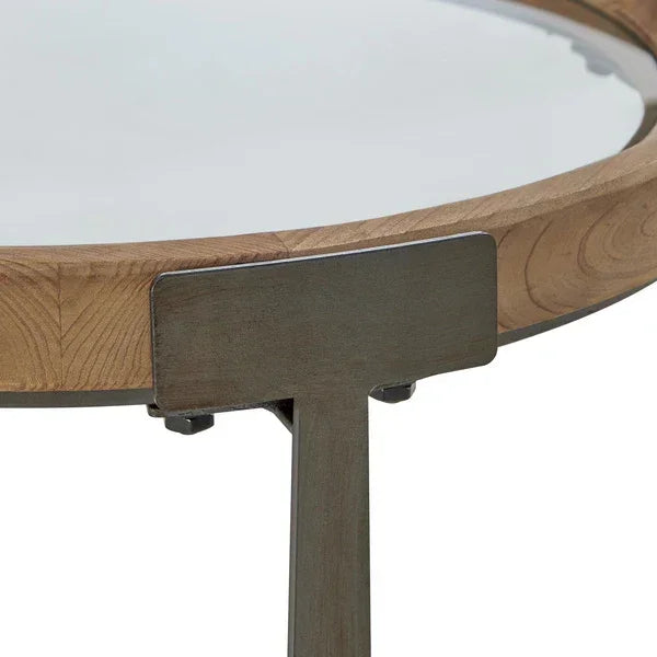 Close view of round glass top coffee table with wood edge and black metal leg detail
