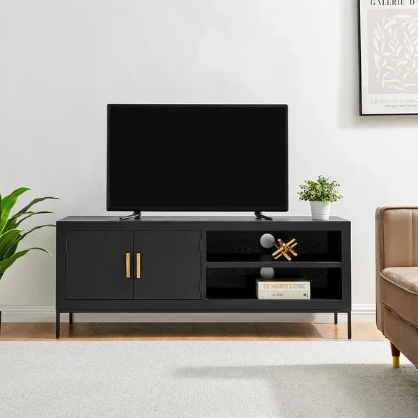 Black TV unit with gold handles, open shelves, decor items, and a flat screen television