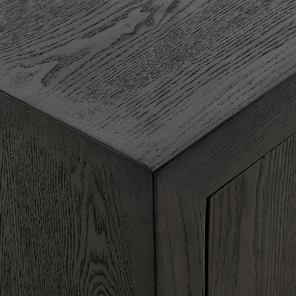 Close-up of black wood veneer cabinet corner with visible grain texture