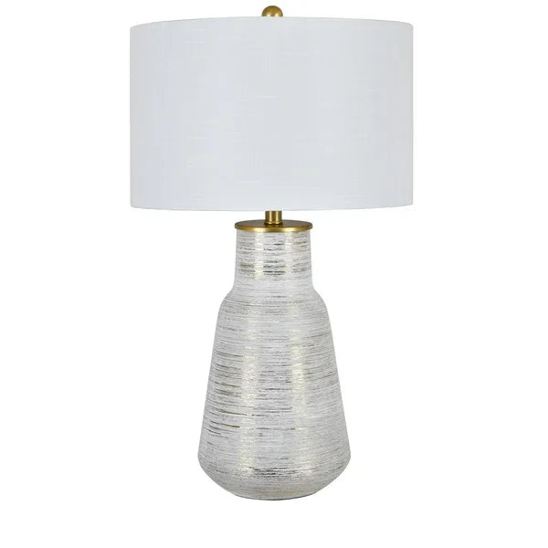 Silver textured table lamp with wide white fabric shade and gold accent detail
