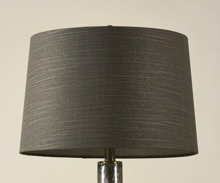 Grey fabric lampshade with textured pattern on table lamp, close-up view