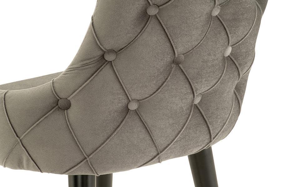 Grey velvet dining chair with button tufted backrest and black wooden legs