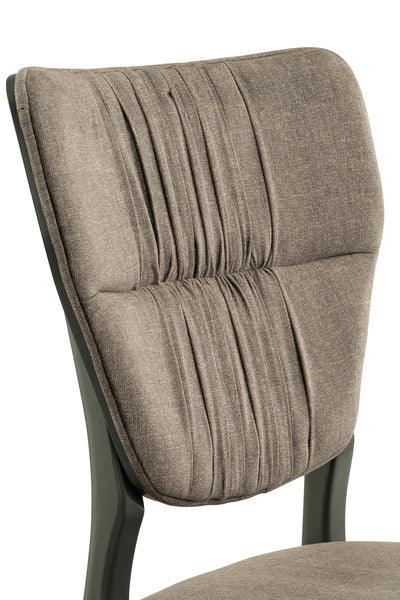 Closeup of taupe fabric dining chair with ruched backrest and dark wooden frame