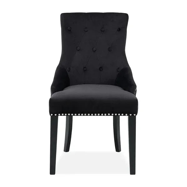 Black velvet dining chair with button-tufted backrest and silver stud detailing, front view