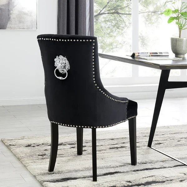 Black velvet dining chair with silver lion head knocker and studded trim in modern room