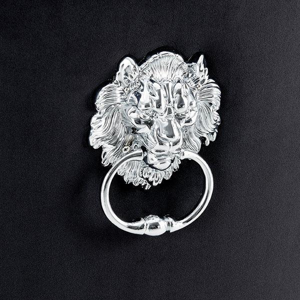 Silver lion head handle ring on black velvet furniture panel