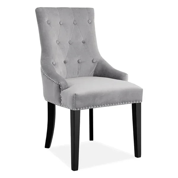 Grey velvet dining chair with button-tufted back and black wooden legs