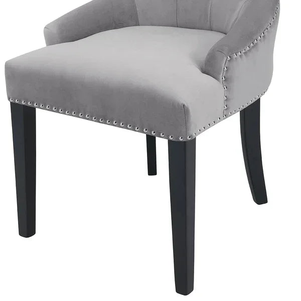 Grey velvet accent chair with studded trim and black wooden legs