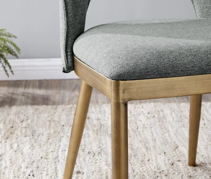 Grey fabric dining chair with wooden legs on textured cream rug