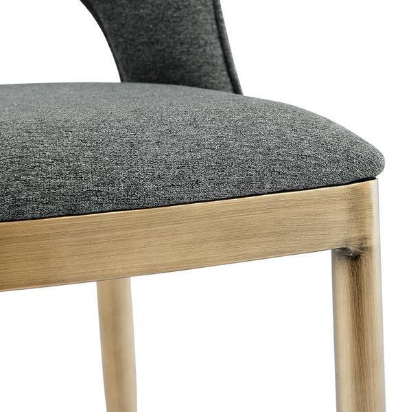 Closeup of dining chair with grey fabric seat and light wood frame