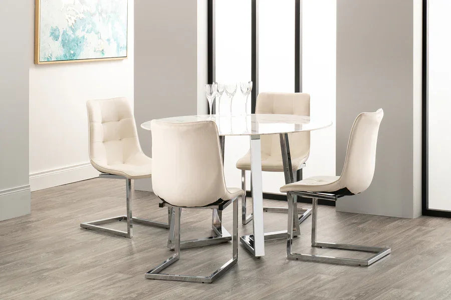 Modern dining table set with round white marble top and four cream chairs on chrome legs