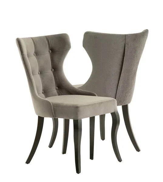 Grey velvet dining chairs with curved backs and button detail, dark wooden legs
