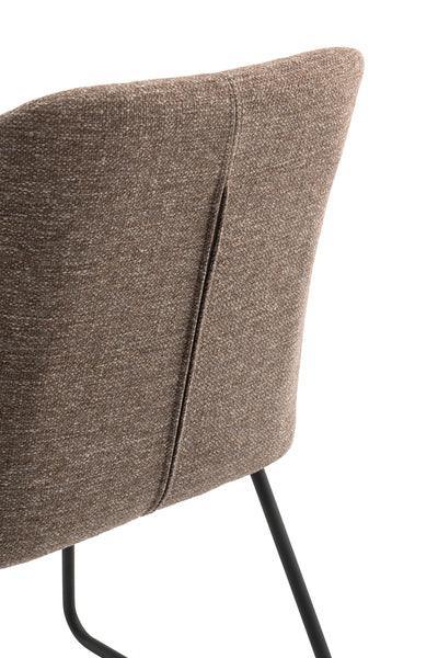 Brown fabric dining chair backrest with black metal legs, angled rear view