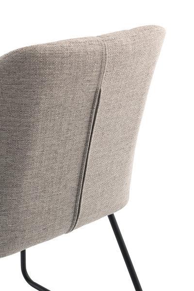 Closeup of grey fabric dining chair backrest with black metal legs
