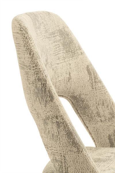 Close-up of beige fabric dining chair with cutout backrest and textured upholstery