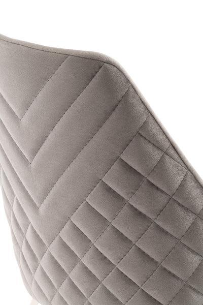 Grey upholstered chair back with quilted diamond stitching detail