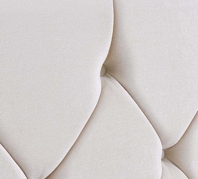 Close-up of cream upholstered sofa cushion with textured tufted design